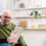 Home caregiver assisting senior man to use telehealth and senior care